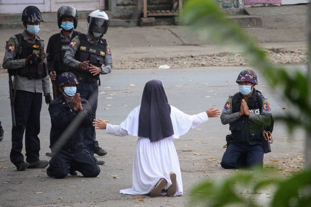 Монахиня становится на колени перед полицией Мьянмы, чтобы остановить насилие
